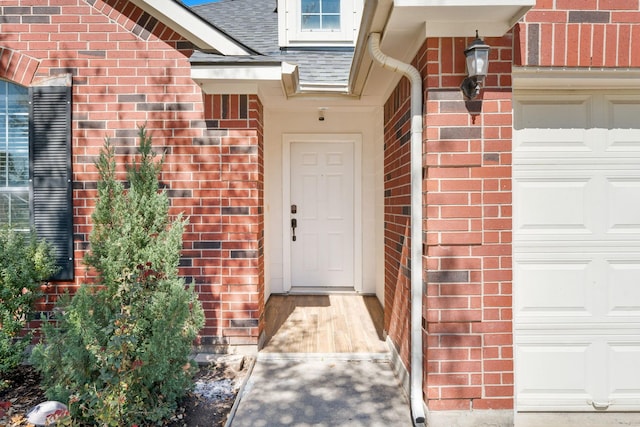 view of exterior entry with brick siding and roof with shingles