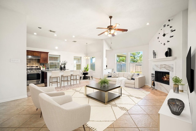 living area with recessed lighting, visible vents, a premium fireplace, baseboards, and ceiling fan with notable chandelier