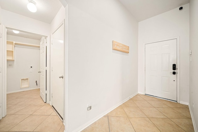 corridor featuring baseboards and light tile patterned floors