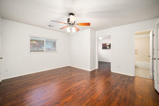 unfurnished room featuring a ceiling fan, wood finished floors, visible vents, and baseboards