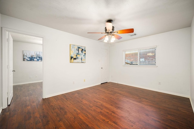 spare room with ceiling fan, wood finished floors, visible vents, and baseboards