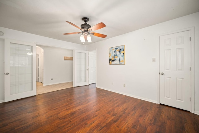 empty room featuring french doors, wood finished floors, a ceiling fan, and baseboards