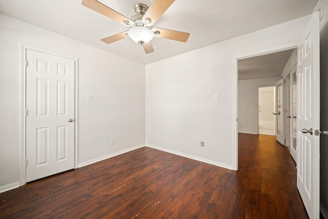 empty room with ceiling fan, baseboards, and wood finished floors