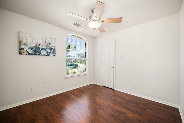 empty room with a ceiling fan, visible vents, baseboards, and dark wood-style flooring