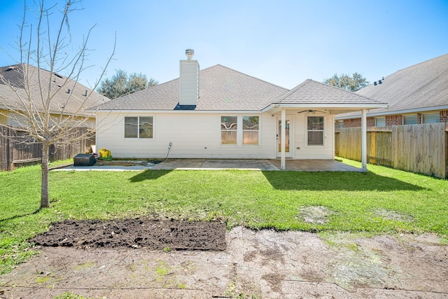 back of house featuring a patio area, a fenced backyard, a ceiling fan, and a lawn