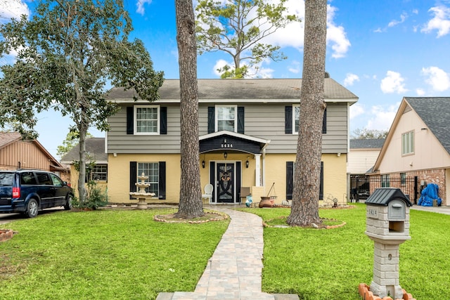 colonial house featuring brick siding, fence, and a front lawn