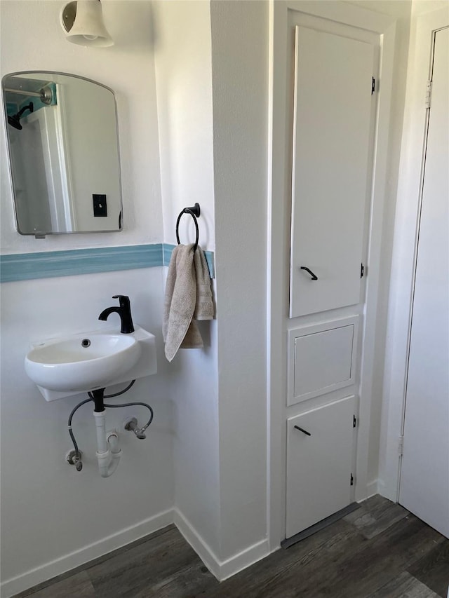 bathroom with a sink, baseboards, and wood finished floors