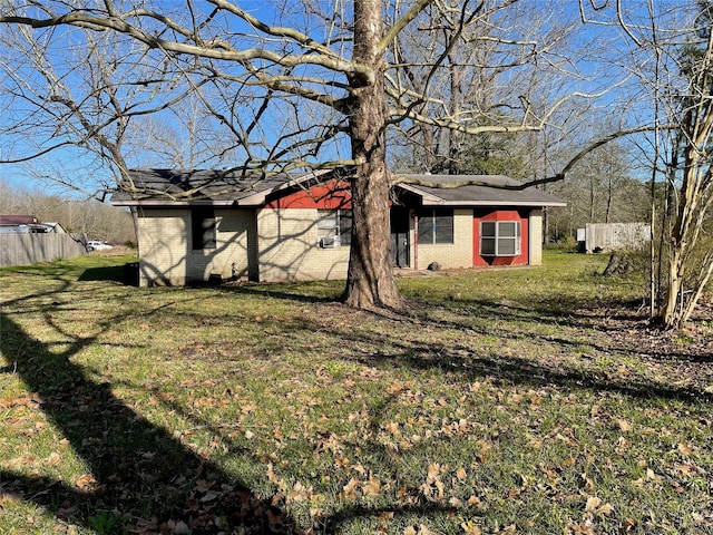 exterior space with fence, a front lawn, and brick siding