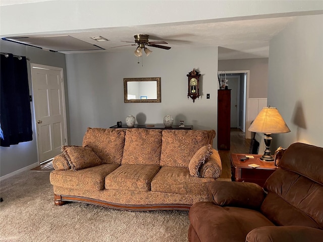 carpeted living room with baseboards, visible vents, and a ceiling fan