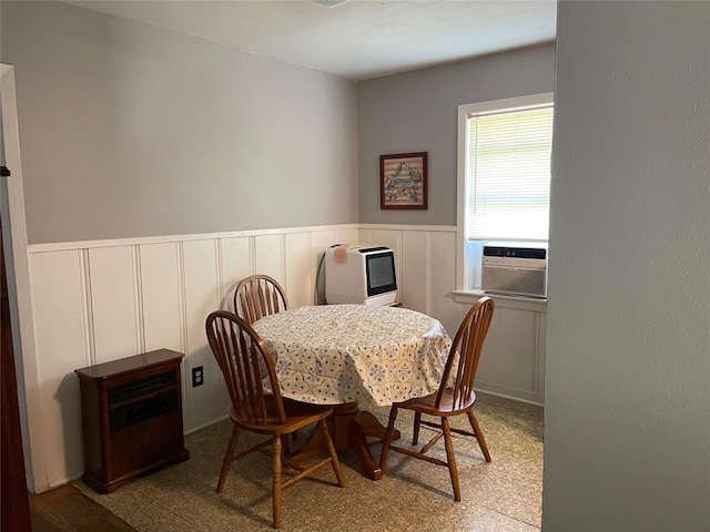 dining space featuring cooling unit and wainscoting