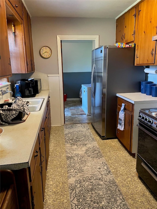 kitchen featuring light floors, double oven range, brown cabinets, and light countertops