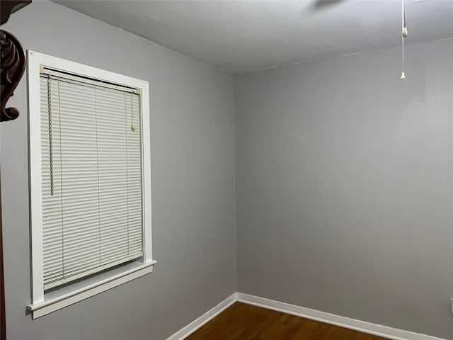 empty room with dark wood-style floors and baseboards