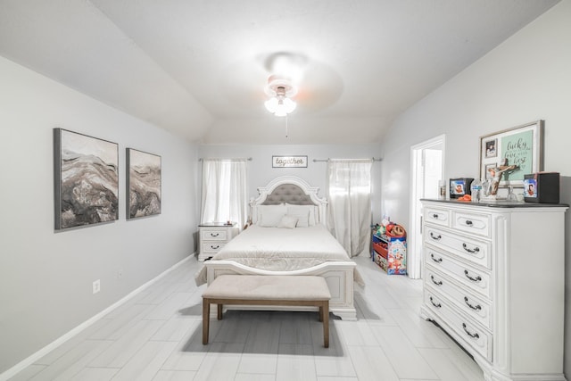 bedroom with vaulted ceiling, a ceiling fan, and baseboards