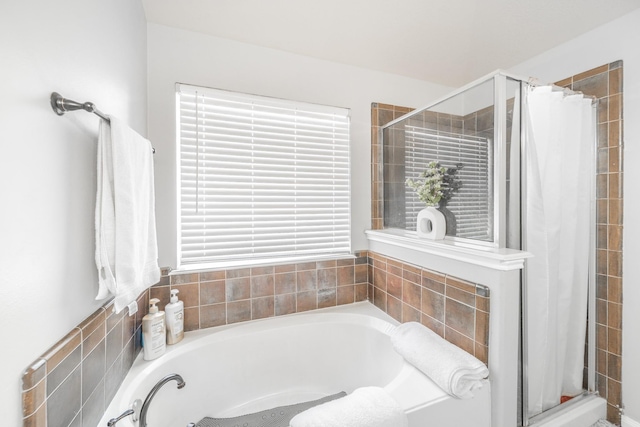 bathroom featuring a stall shower and a garden tub