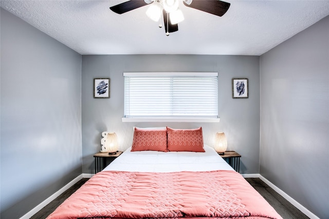 bedroom featuring ceiling fan, baseboards, and a textured ceiling