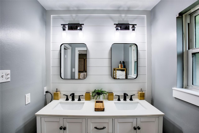 full bathroom with double vanity and a sink