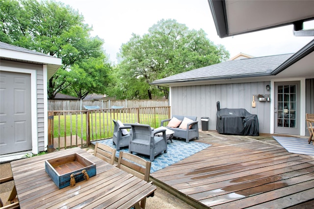 deck with a lawn, grilling area, an outdoor living space with a fire pit, and fence