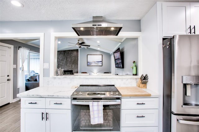 kitchen featuring lofted ceiling, light stone counters, island exhaust hood, stainless steel appliances, and white cabinetry