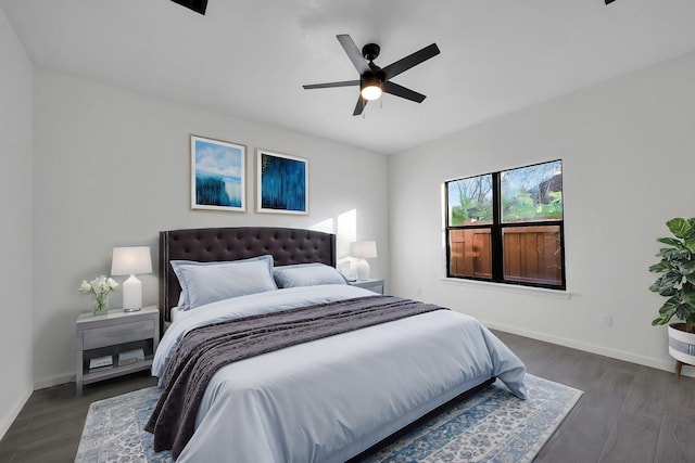 bedroom featuring dark wood-style flooring, a ceiling fan, and baseboards