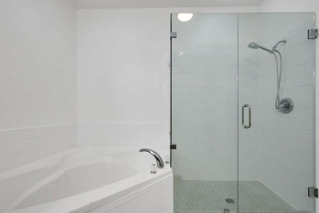 bathroom featuring a garden tub and a shower stall