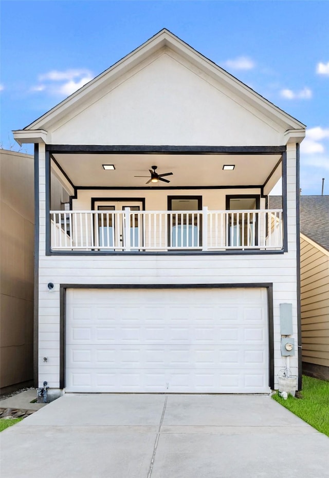 view of front of house with concrete driveway, an attached garage, a balcony, and stucco siding