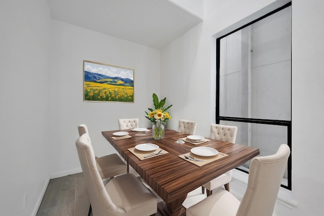 dining space featuring baseboards and wood finished floors