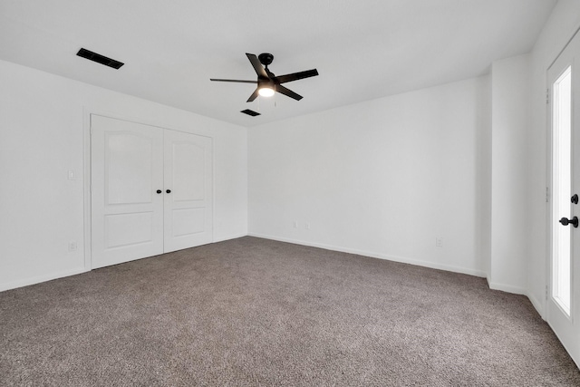 unfurnished bedroom with carpet, a closet, ceiling fan, and baseboards