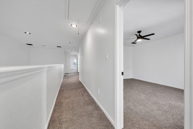 hall with attic access, recessed lighting, carpet flooring, and baseboards