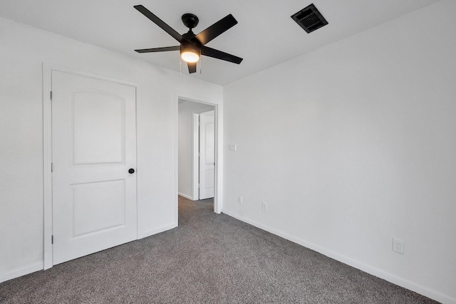 unfurnished bedroom with ceiling fan, baseboards, visible vents, and dark carpet