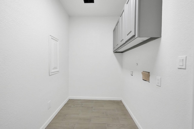 washroom featuring visible vents, light floors, cabinet space, and baseboards