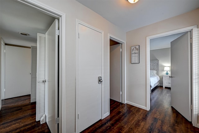 hallway with dark wood-style floors and baseboards