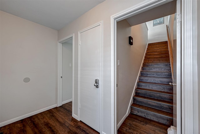 staircase featuring baseboards and wood finished floors