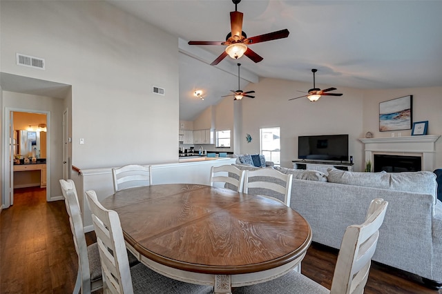 dining room featuring dark wood-style flooring, visible vents, and a fireplace