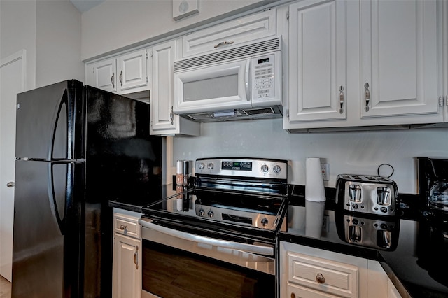 kitchen featuring dark countertops, white cabinetry, electric range, and white microwave