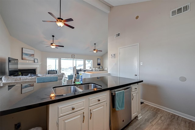 kitchen featuring a sink, visible vents, white cabinets, open floor plan, and stainless steel dishwasher