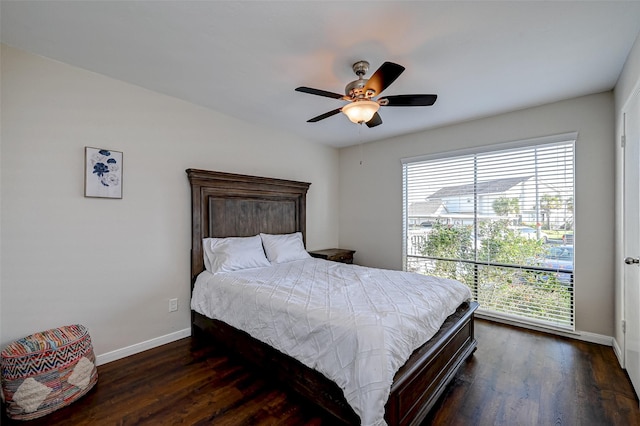 bedroom with dark wood-style floors, a ceiling fan, and baseboards