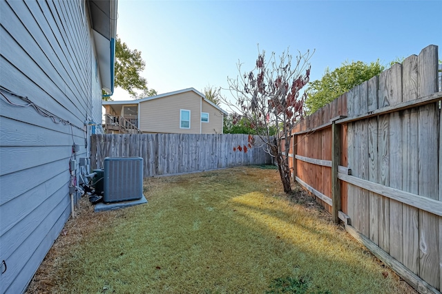 view of yard with a fenced backyard and central AC unit