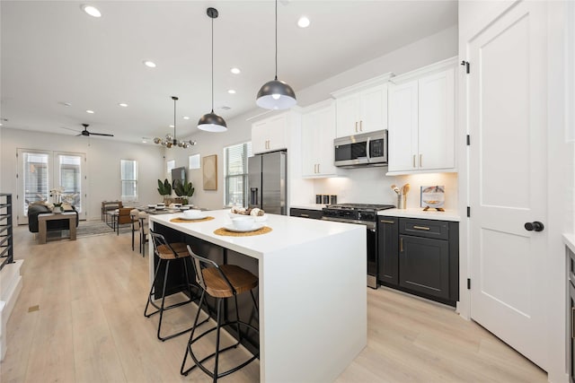 1909 Johanna Dr, Houston, TX 77055 - kitchen with appliances with stainless steel finishes, a breakfast bar, a center island, light countertops, and recessed lighting