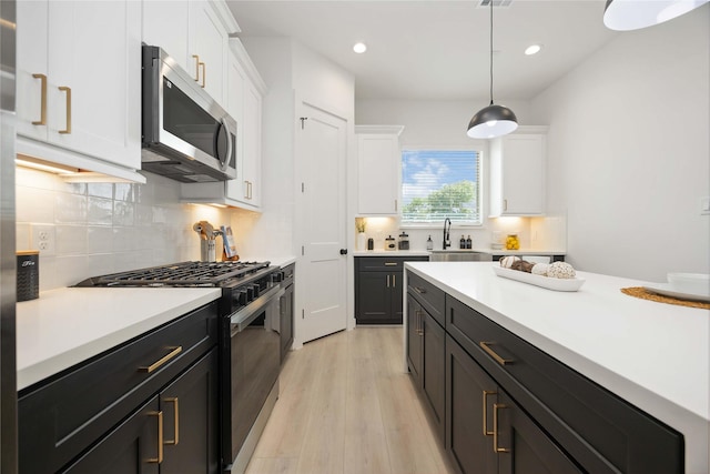 1909 Johanna Dr, Houston, TX 77055 - kitchen with appliances with stainless steel finishes, a sink, white cabinets, light countertops, and recessed lighting