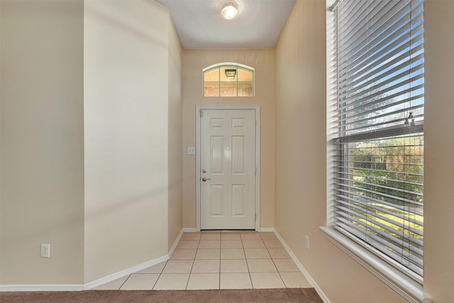 entryway featuring light carpet and baseboards