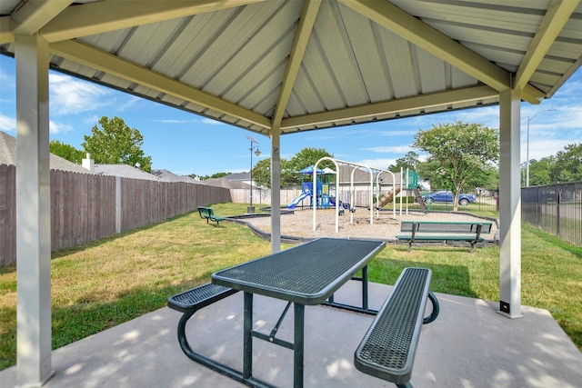 view of patio with playground community and fence