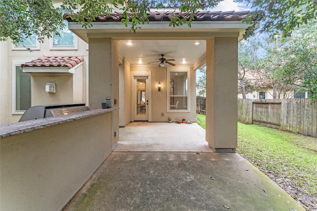 view of patio featuring an outdoor kitchen, a fenced backyard, and a ceiling fan