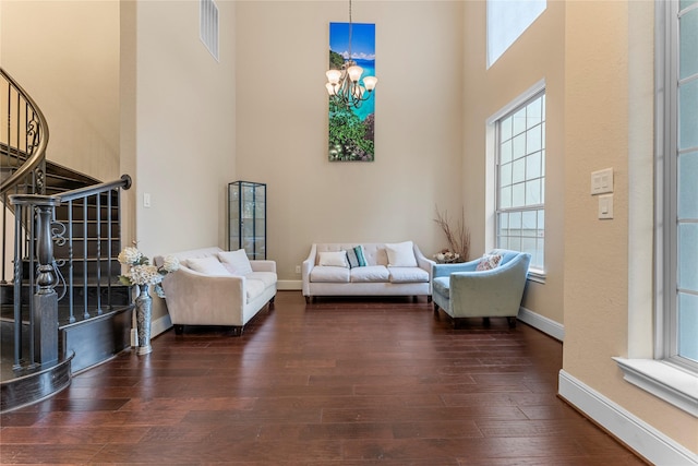 living area with visible vents, dark wood finished floors, a high ceiling, and stairs