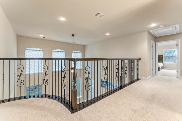 hallway with carpet floors, attic access, visible vents, and recessed lighting