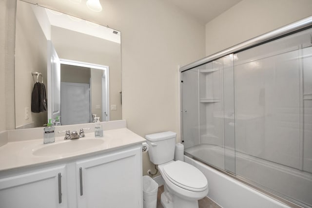 bathroom with combined bath / shower with glass door, vanity, and toilet