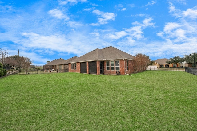 back of property featuring brick siding, a lawn, and a fenced backyard