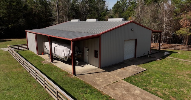 view of pole building featuring a yard and fence