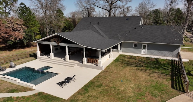 back of house featuring a patio, fence, roof with shingles, a lawn, and a fenced in pool