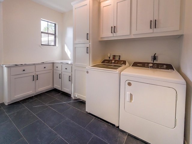 clothes washing area with washing machine and dryer, cabinet space, and dark tile patterned flooring