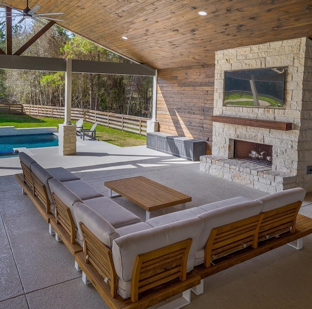 exterior space with fence, an outdoor stone fireplace, and an outdoor pool